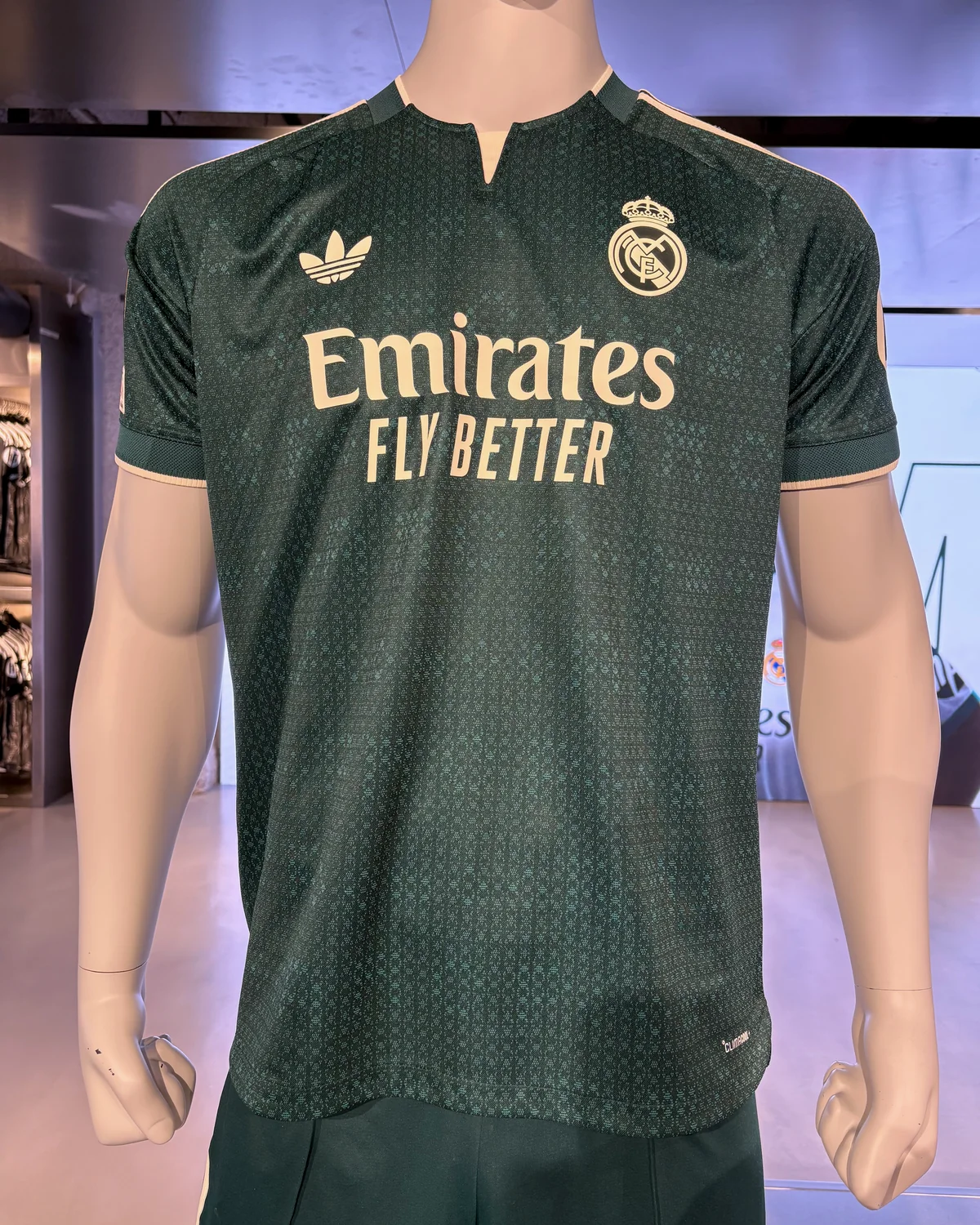 Green Real Madrid 2026/27 away shirt on a mannequin in a store display